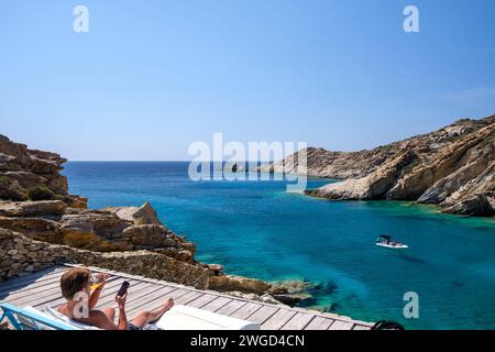 IOS, Grèce - 15 septembre 2023 : vue d'un touriste jouissant de la vue panoramique depuis le sommet d'une falaise à l'incroyable plage de Tripiti à iOS Grèce Banque D'Images