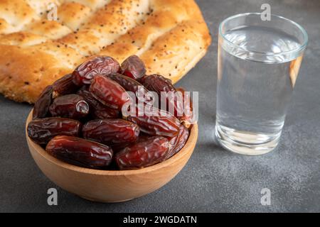 Table traditionnelle iftar avec fruits de dattes, olive et ramadan pita sur fond noir Banque D'Images