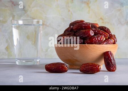 Table traditionnelle iftar avec des dates et un verre d'eau, devant un fond lumineux Banque D'Images