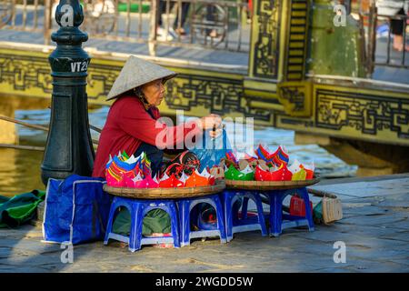 Une dame âgée vendant des lanternes près de la rivière Thu bon, Hoi an, Vietnam Banque D'Images