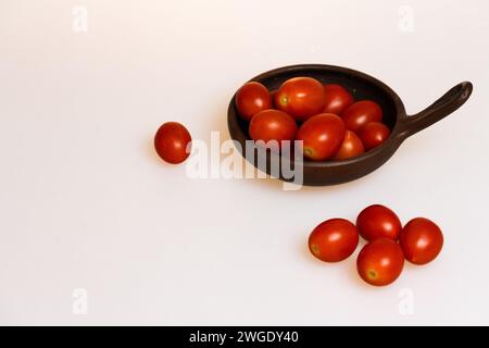 tomates prunes dans un plat en argile avec fond blanc vue de dessus Banque D'Images