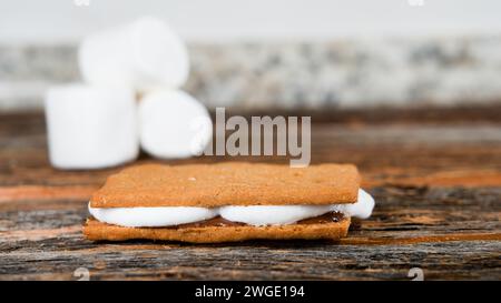 Crackers Grahams avec guimauves et chocolat sur table en bois avec espace copie Banque D'Images