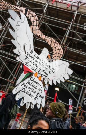 Londres, Royaume-Uni. 3 février 2024. Une bannière en forme de colombe de la paix et en soutien aux enfants qui souffrent pendant la guerre Israël - Gaza tenue par des militants de la paix et des manifestants pendant la marche Pro - Palestine à travers Oxford Street à Soho, mouvement libre Palestine , Londres, Royaume-Uni Banque D'Images