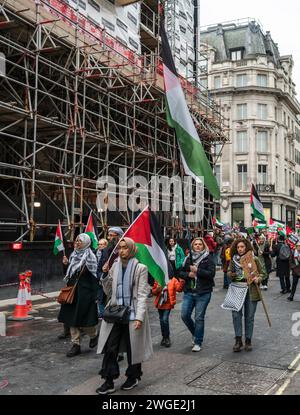 Londres, Royaume-Uni. 3 février 2024. Drapeaux palestiniens tenus par des militantes pour la paix et des protestataires lors de la marche Pro - Palestine près d'Oxford Street à Soho, Londres, Royaume-Uni Banque D'Images