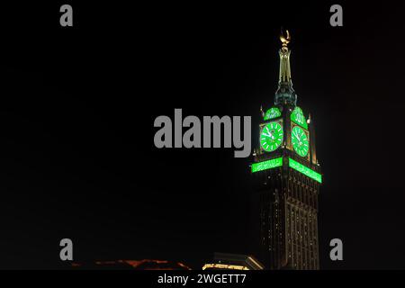 La Mecque, Arabie Saoudite - 07 mars 2023 : tour de veille illuminée verte du bâtiment Abraj Al Bait à la Mecque contre le ciel nocturne noir. Hauteur 601m il est quatre Banque D'Images