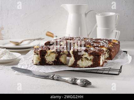 Délicieux gâteau au chocolat fait maison avec des boules de caillé-noix de coco sur une table blanche. Décoré avec croquant à la noix de coco. Banque D'Images