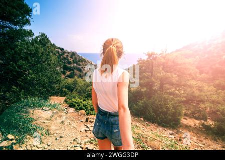 Fille tient sa main de petit ami en vacances un jour ensoleillé dans le fond des montagnes et de la mer Banque D'Images