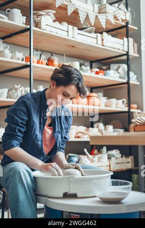 Une femme céramiste à une roue de poterie dans un atelier Banque D'Images