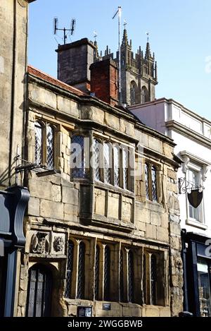 Bâtiment du tribunal de Glastonbury le long de High Street dans le centre-ville avec la tour de l'église St Jean Baptiste à l'arrière, Glastonbury, Royaume-Uni. Banque D'Images