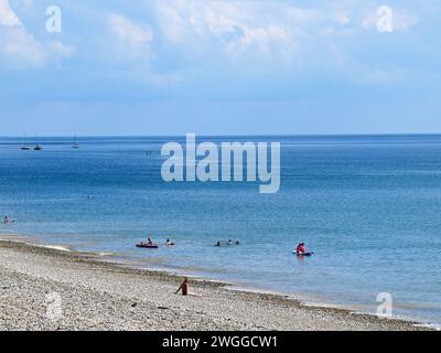 Touristes se relaxant sur la plage avec vue sur la mer, Seaton, Devon, Royaume-Uni, Europe. Banque D'Images