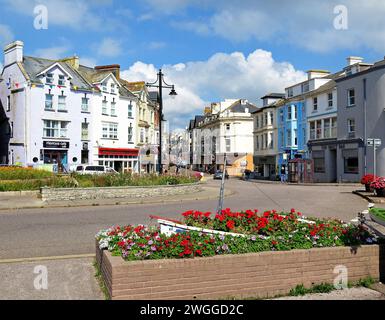 Vue sur les boutiques de Fore Street dans le centre-ville avec de jolis parterres de fleurs au premier plan, Seaton, Devon, Royaume-Uni, Europe. Banque D'Images