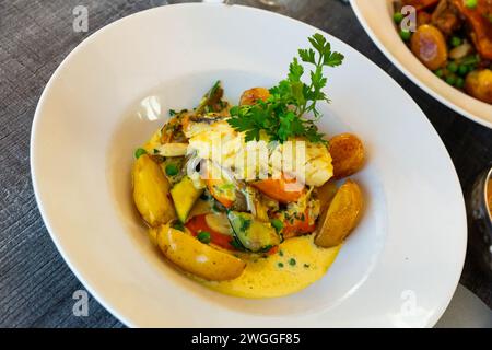 Filet de merlu avec légumes et pommes de terre. Plat français Banque D'Images