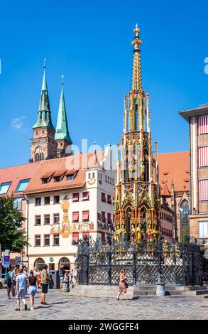 Vue de la fontaine Schöner Brunnen sur le marché principal de Nuremberg, Allemagne, avec les tours de connexion Église de Sebaldus en arrière-plan. Banque D'Images