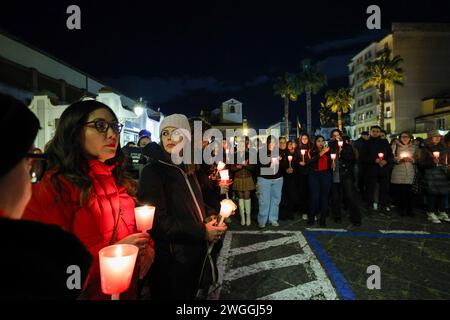 Personnes lors d'une procession aux flambeaux pour la Journée internationale pour l'élimination de la violence à l'égard des femmes. En Italie, les rassemblements se déroulent au milieu d'un outpo Banque D'Images