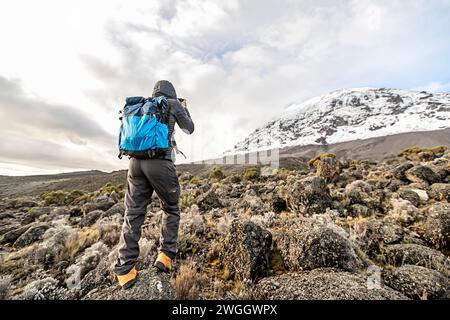 Randonneur photographiant le sommet enneigé du mont Kilimandjaro, Tanzanie Banque D'Images