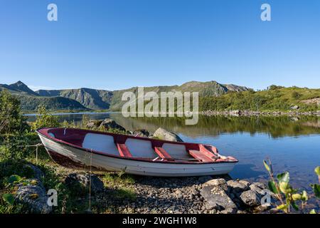 Un bateau amarré repose paisiblement sur la plage de sable au bord du lac Banque D'Images