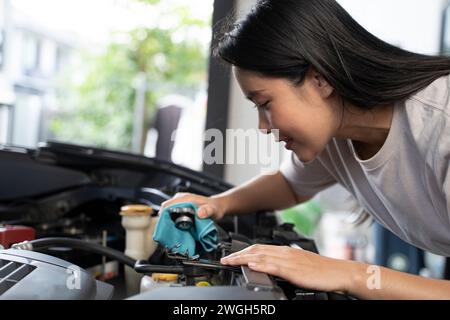 Une femme vérifie le niveau de liquide de refroidissement du moteur. Banque D'Images