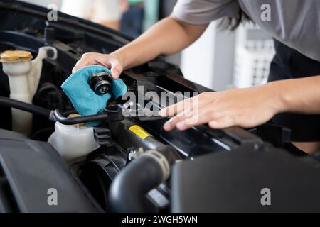 Une femme vérifie le niveau de liquide de refroidissement du moteur. Banque D'Images