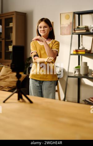 Adolescente avec un bras partiel dansant devant l'écran du smartphone tout en enregistrant une vidéo ou en faisant du livestream pour les abonnés Banque D'Images