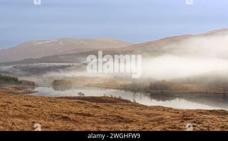 Brume matinale s'élevant au-dessus d'un Loch et des collines en hiver sur la côte ouest 0f Écosse Banque D'Images