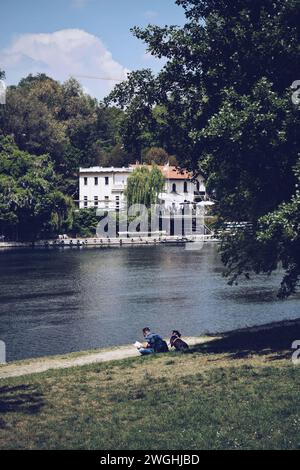 Homme assis avec son chien sur les rives du Pô à Turin, Italie. Le 9 mai 2022 Banque D'Images