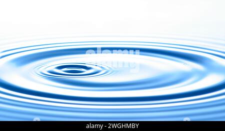 une goutte provoque des vagues circulaires à la surface de l'eau Banque D'Images