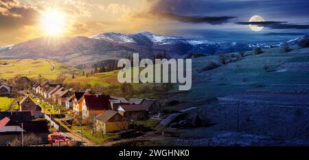 paysage rural des carpates au printemps. village ukrainien dans la vallée. arable sur la colline alpine. montagne enneigée au loin. jour et ni Banque D'Images