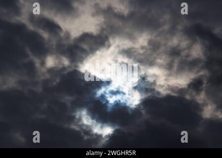 Une éclipse solaire partielle du 25 octobre 2022 capturée à travers des nuages sombres de mauvaise humeur, la phase maximale visible depuis l'Europe, la Roumanie. Banque D'Images