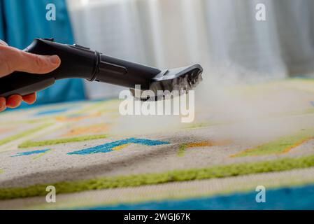 tapis de nettoyage dans la chambre des enfants avec vapeur Banque D'Images