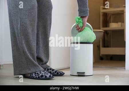 Femme au foyer jetant les ordures, prenant le sac poubelle en plastique de la poubelle dans l'appartement Banque D'Images