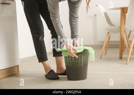 Femme au foyer jetant les ordures, prenant le sac poubelle en plastique de la poubelle dans l'appartement Banque D'Images