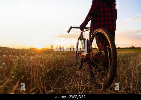 Silhouette d'un cycliste et de son vélo sur fond de ciel de coucher de soleil. Concept de santé et de style de vie sportif. Banque D'Images