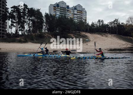 Adrien Vautier/le Pictorium - les sportifs s'entraînent en Ukraine pendant la guerre - 13/11/2023 - Ukraine/Kiev - L'équipe ukrainienne masculine de kayak sprint s'entraîne sur la rivière Stugna. L'équipe a fait prendre un rond d'acier d'un char russe brûlé, qu'elle transformera en médailles gravées avec les mots 'Paris 2024', avant de les présenter à Thomas Konietzko, président de la Fédération mondiale de canoë, devant les caméras. Ce dernier a reconnu qu'"il n'est pas possible pour les Russes de participer aux Jeux de 2024 sous leur drapeau". Kiev, 13 novembre 2023. Banque D'Images