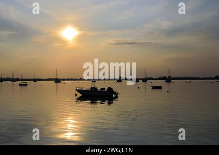 Coucher de soleil sur des bateaux à Mudeford Quay, Christchurch Harbour, Dorset ; Angleterre, Royaume-Uni Banque D'Images