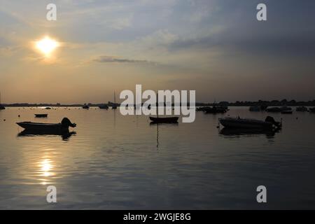 Coucher de soleil sur des bateaux à Mudeford Quay, Christchurch Harbour, Dorset ; Angleterre, Royaume-Uni Banque D'Images