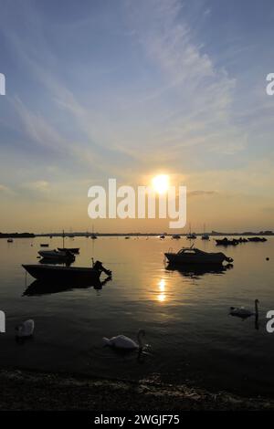 Coucher de soleil sur des bateaux à Mudeford Quay, Christchurch Harbour, Dorset ; Angleterre, Royaume-Uni Banque D'Images