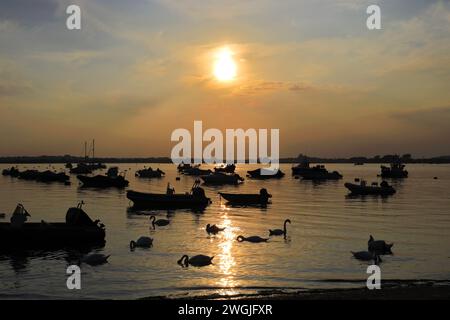 Coucher de soleil sur des bateaux à Mudeford Quay, Christchurch Harbour, Dorset ; Angleterre, Royaume-Uni Banque D'Images