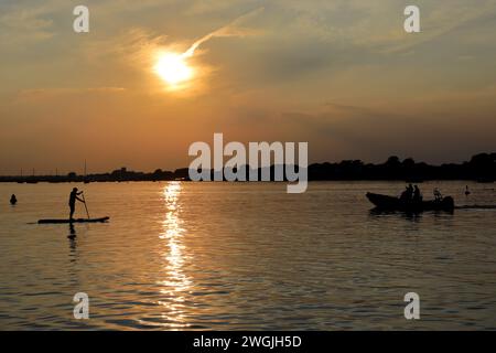 Coucher de soleil sur des bateaux à Mudeford Quay, Christchurch Harbour, Dorset ; Angleterre, Royaume-Uni Banque D'Images