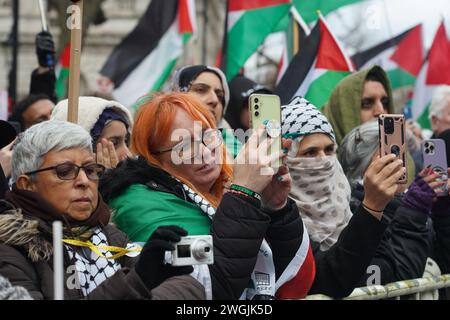 Les manifestants filment sur leurs téléphones alors que des centaines de milliers de manifestants pro-palestiniens réclamant un cessez-le-feu à Gaza se rassemblent à Whitehall. Banque D'Images