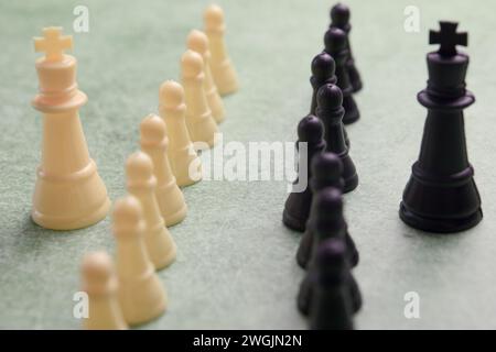 Concentration intense sur les personnages d'échecs finement sculptés baignés d'un vert éclatant, capturant l'essence de la bataille stratégique et l'allure intemporelle Banque D'Images