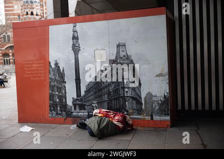 Homme sans-abri repose sur le trottoir de Victoria Street dans le centre de Londres, Angleterre, Royaume-Uni Banque D'Images