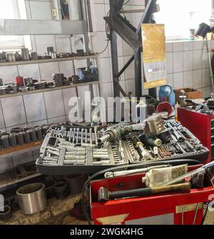 Un objectif sélectif de la boîte à outils du mécanicien avec des outils dans les tiroirs. Pièces de rechange pour voitures sur les étagères. Banque D'Images