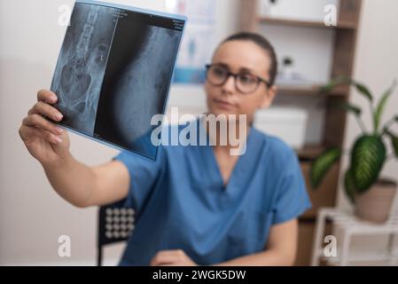 Docteur en gommages bleus analyse le film de rayons X pour fournir des services de soins de santé et diagnostiquer le patient Banque D'Images