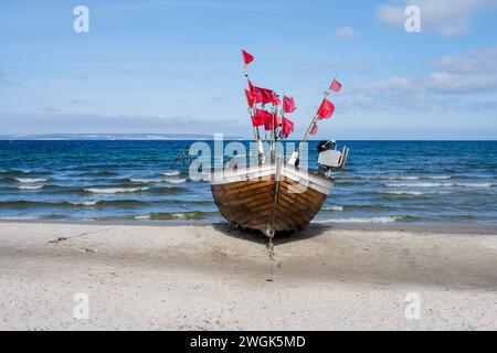 Ein Fischerboot am Strand von Binz auf Rügen mit roten Fahnen der Netzbojen Banque D'Images