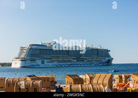 Strand von Heigkendorf an der Kieler Förde das Kreuzfahrtschiff AIDA nova fährt vorbei im Vordergrund eine Badeinsel mit Jugendlichen Banque D'Images