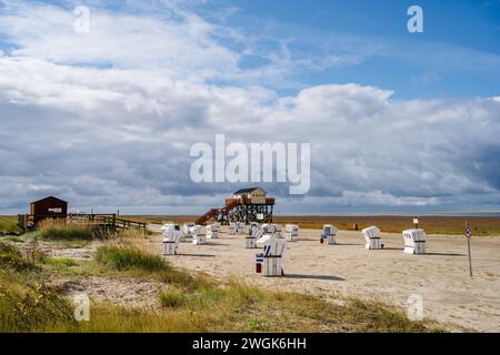Nordseestrand mit Strandkörben und Pfahlbauten am sonnigen Strand von réunies Peter Ording im Sommer *** plage de la mer du Nord avec chaises longues et habitations sur la plage ensoleillée de St Peter Ording en été Banque D'Images