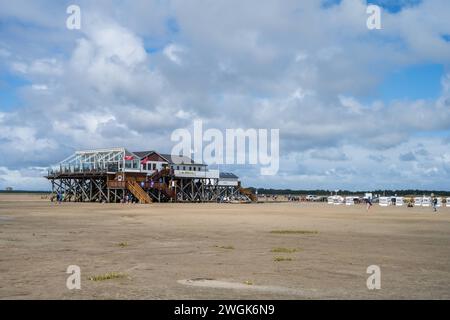 Nordseestrand mit Strandkörben und Pfahlbauten am sonnigen Strand von réunies Peter Ording im Sommer *** plage de la mer du Nord avec chaises longues et habitations sur la plage ensoleillée de St Peter Ording en été Banque D'Images