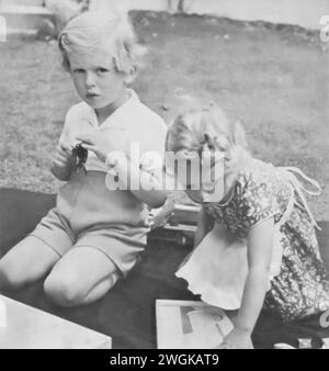 Photographie de la princesse Alexandra et du prince Edward jouant sur la pelouse en 1939. En tant que cousins germains de la future reine Elizabeth II, cette image capture les jeunes années de la famille royale. Alexandra, née en 1936, et Edward, né en 1935, font partie de la famille royale élargie pendant le début du règne du roi George VI, le père d'Elizabeth. Banque D'Images