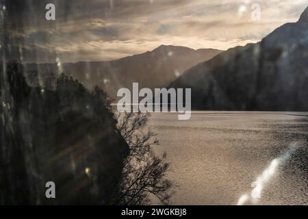 Regardant par la fenêtre du train Oslo-Bergen, Norvège, coucher de soleil dans un fjord Banque D'Images