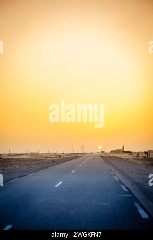 Conduite à travers un village dans le désert en Mauritanie au coucher du soleil Banque D'Images